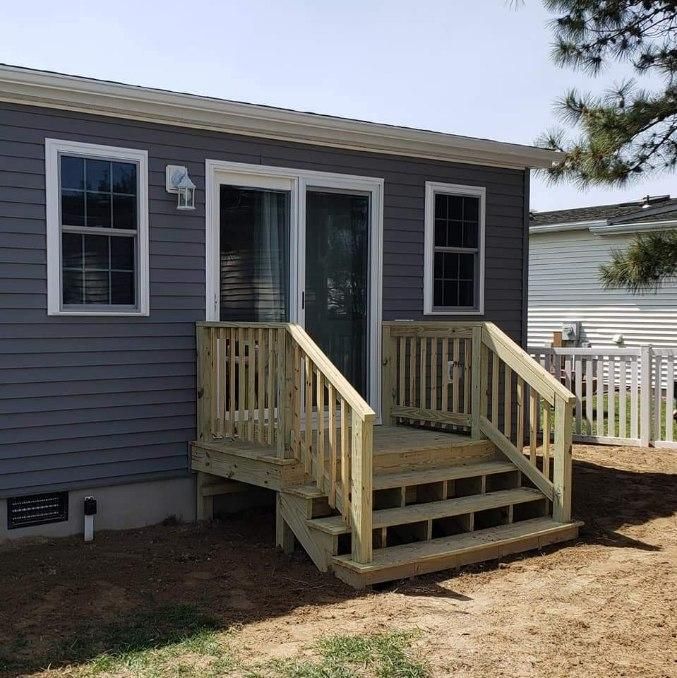 A small house with a wooden deck and stairs