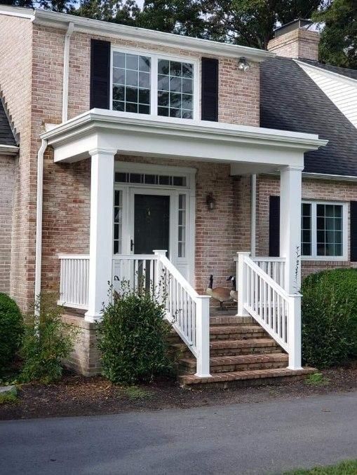 A brick house with a white porch and stairs