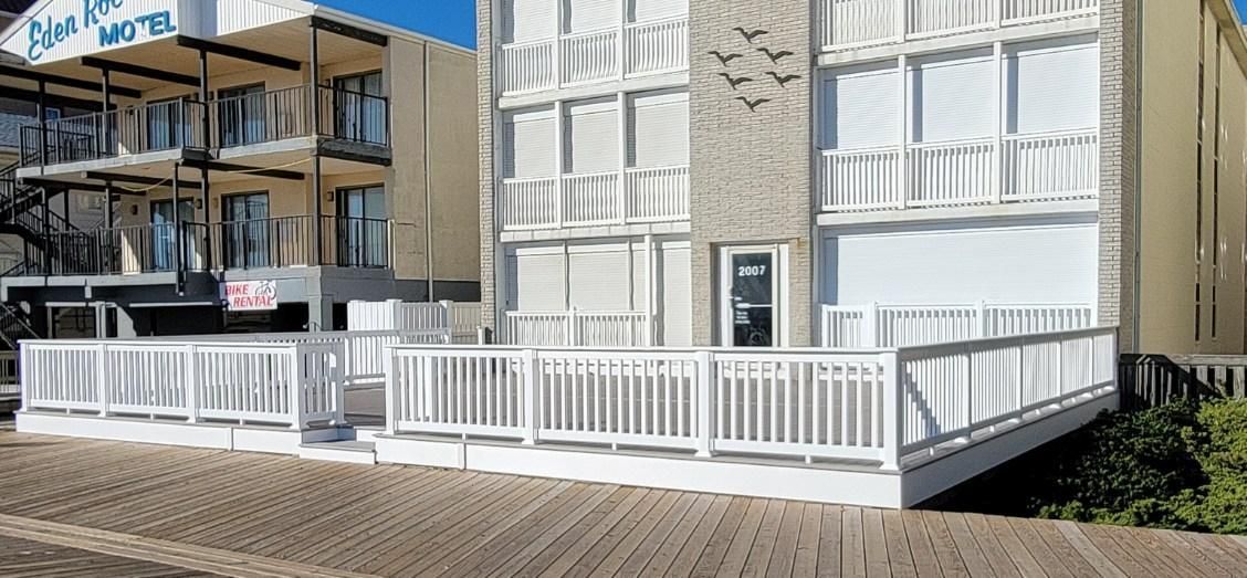 A large building with a white fence and a ramp leading to it.
