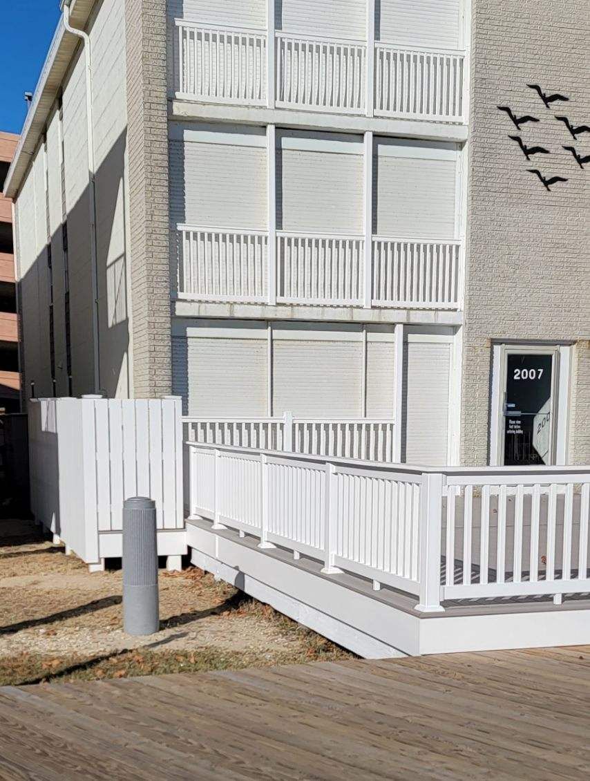 A white building with a ramp and a balcony on the side of it.
