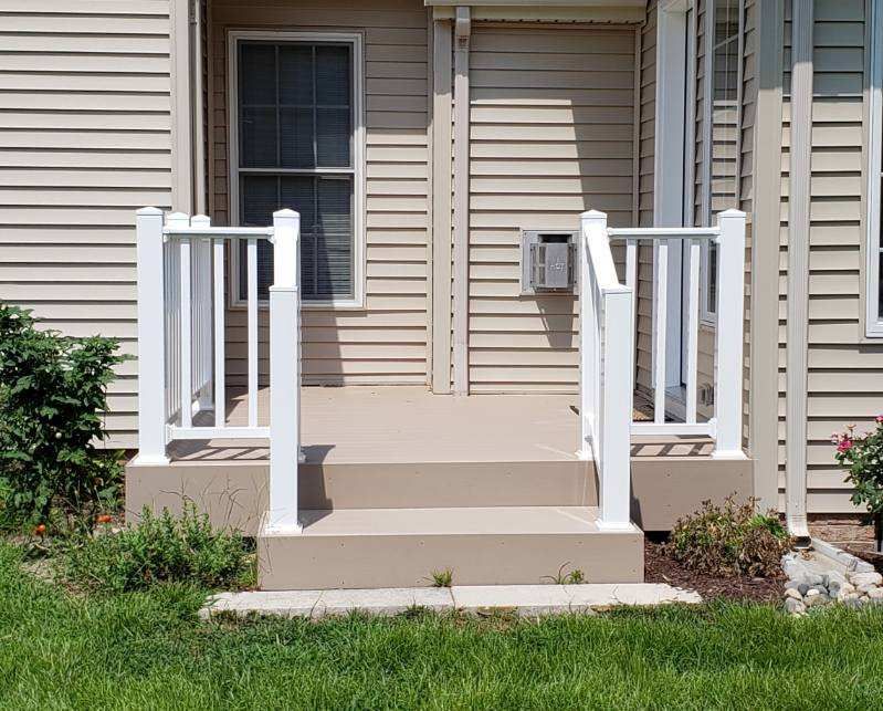 A house with a porch and stairs with a white railing