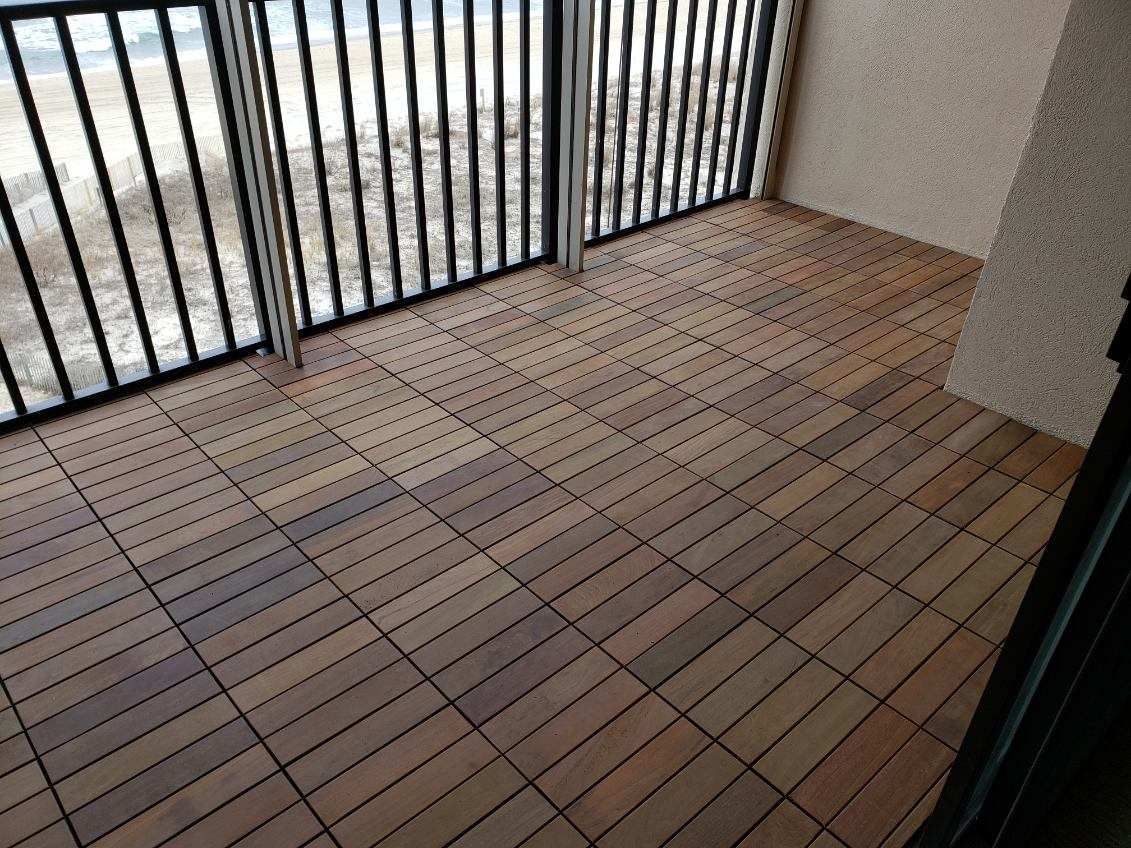 A balcony with a wooden floor and a metal railing.