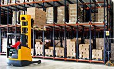 Worker in forklift truck loading boxes