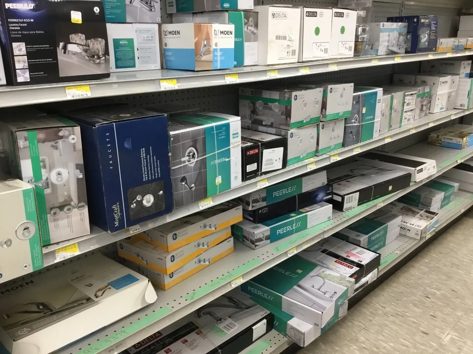 Store shelf stocked with various boxed electronics and accessories in blue, white, and green packaging.