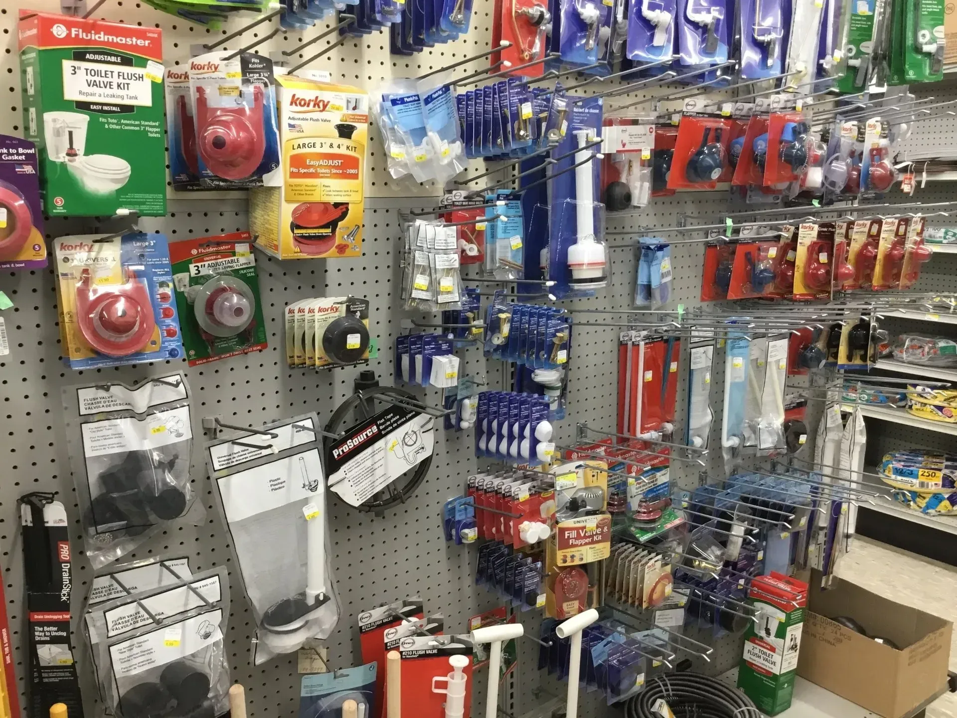 Store aisle with assorted small hardware and accessories displayed on pegboards and shelves