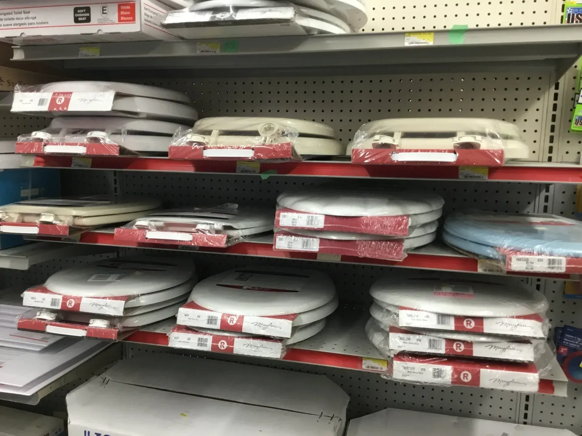 Store shelf stocked with stacked white boxed items and red price tags in a retail aisle
