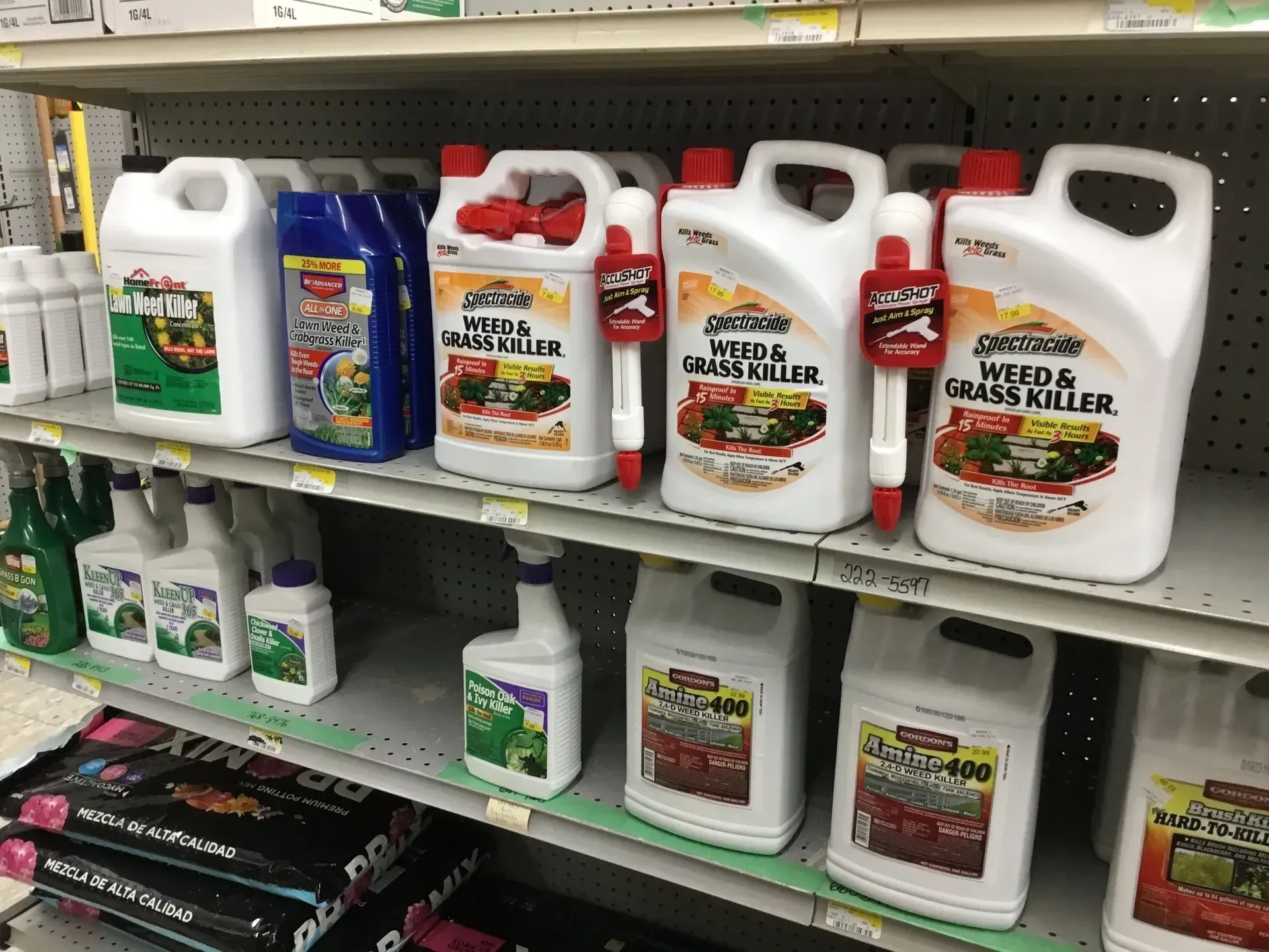 Shelves of garden fertilizer jugs and containers in a store aisle