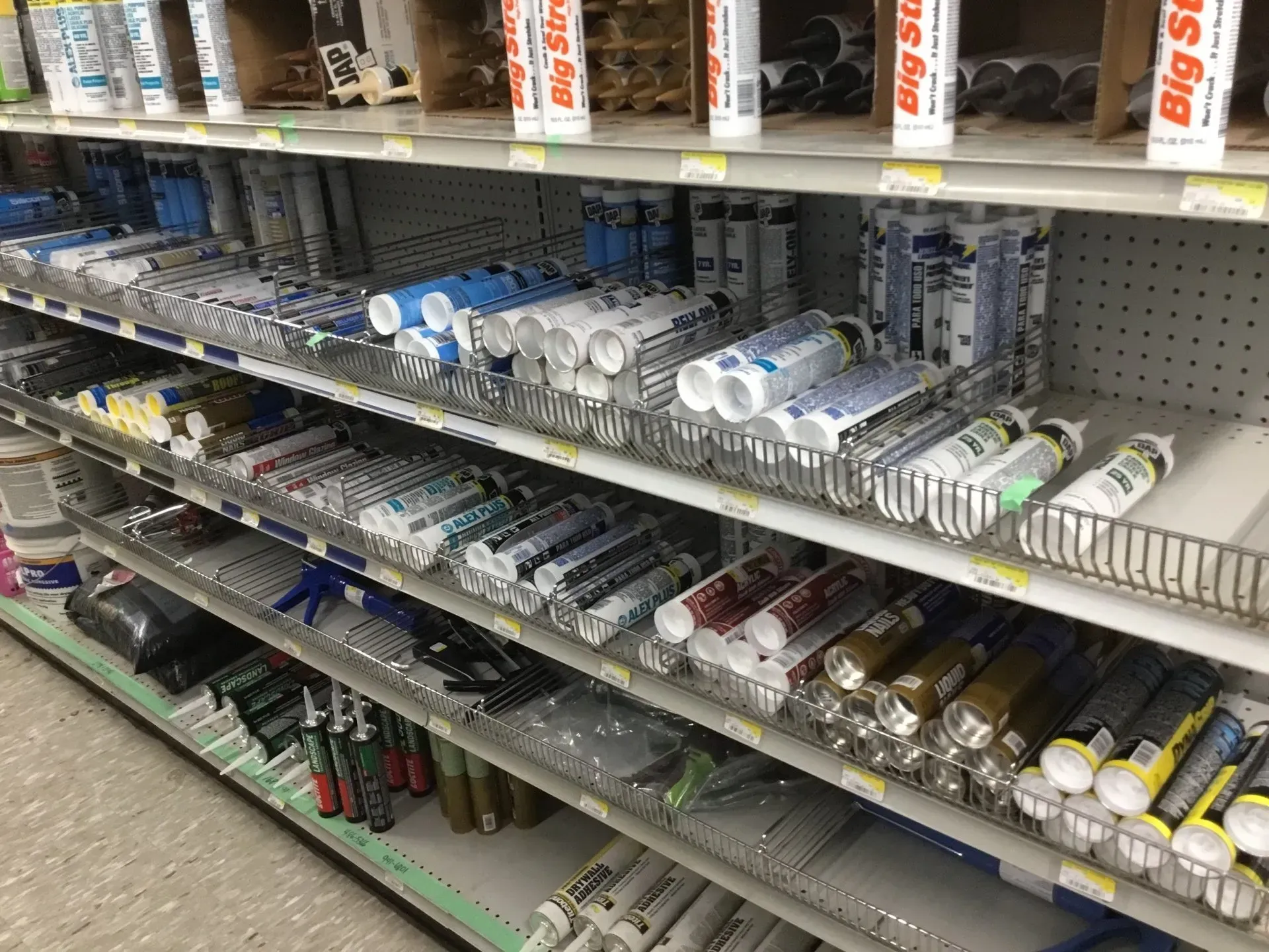 Store shelf with rows of assorted bottled drinks and beverages in a convenience store aisle