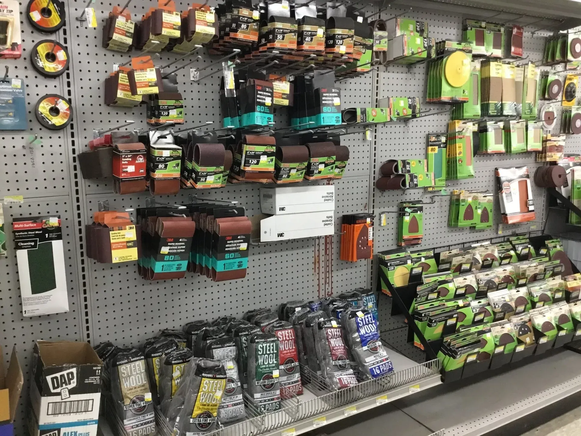 Store display of assorted fishing lures and tackle packages on pegboard shelves