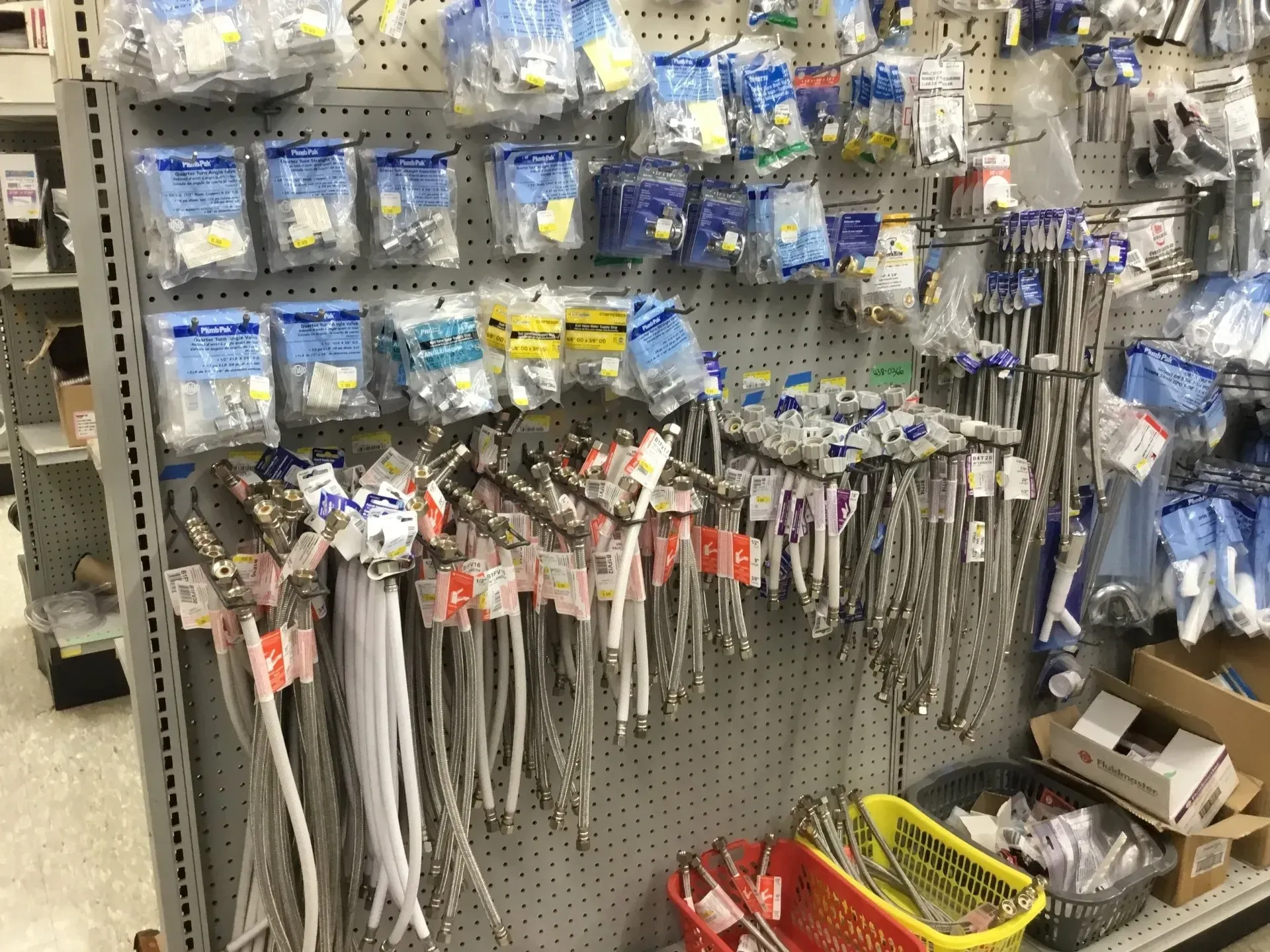 Hardware store pegboard with packaged zip ties and cable ties hanging in rows, plus bins below.