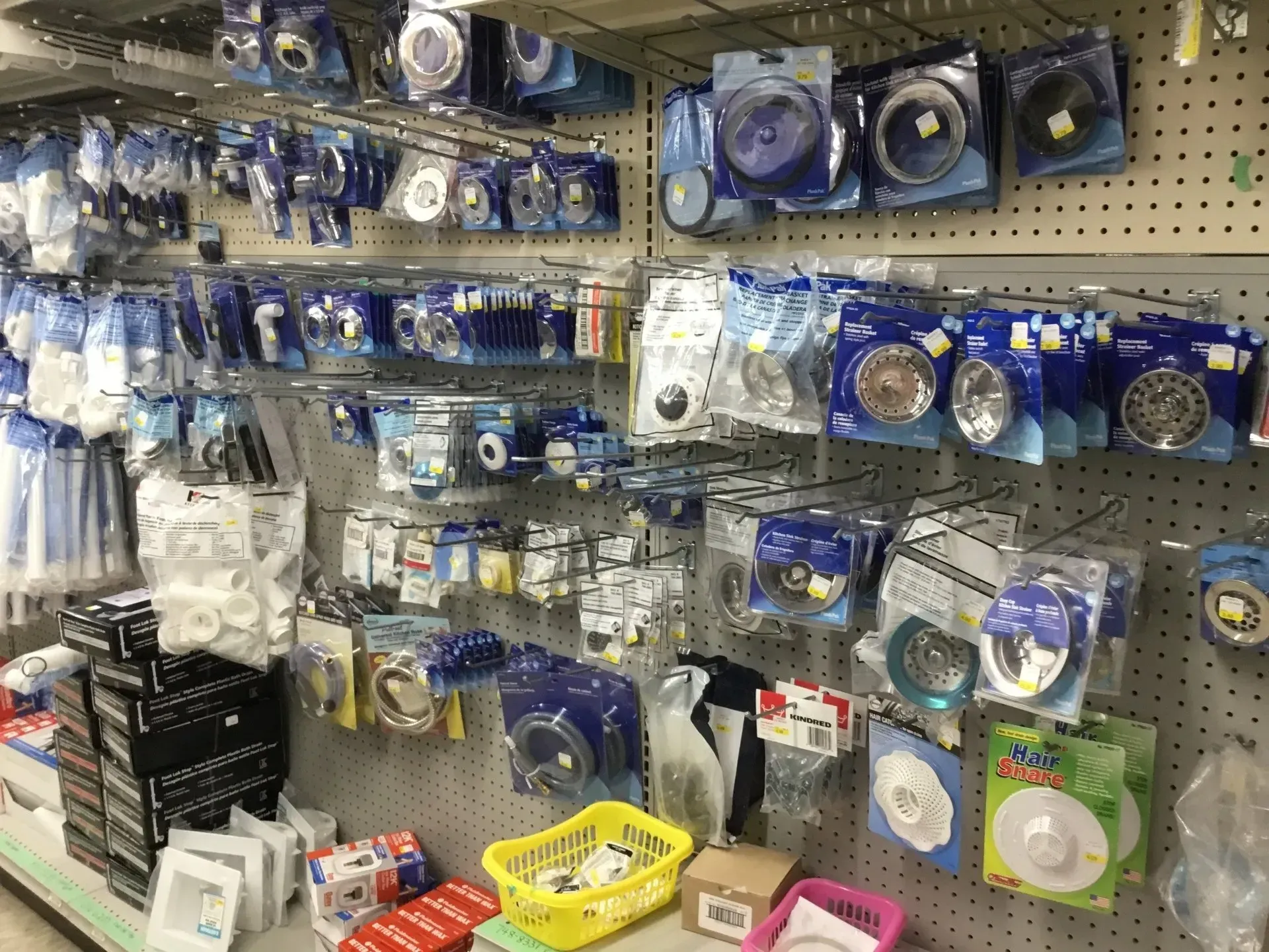 Store aisle with many packaged blue and white circular parts and accessories displayed on pegboard shelves.