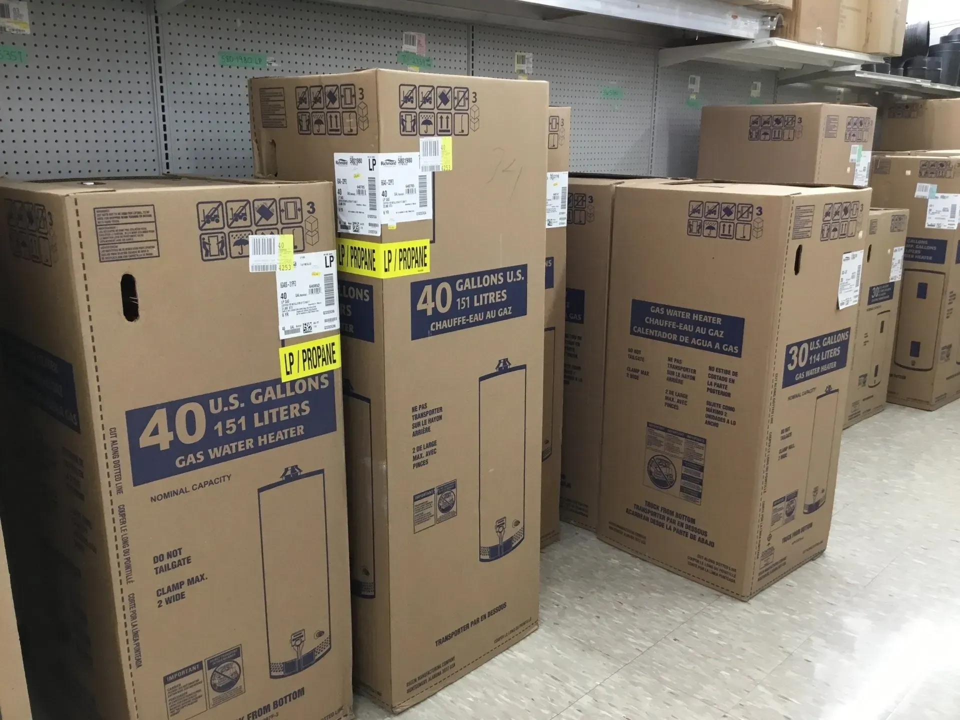 Aisle in a store with stacked cardboard boxes of 40-inch flat-screen TVs.