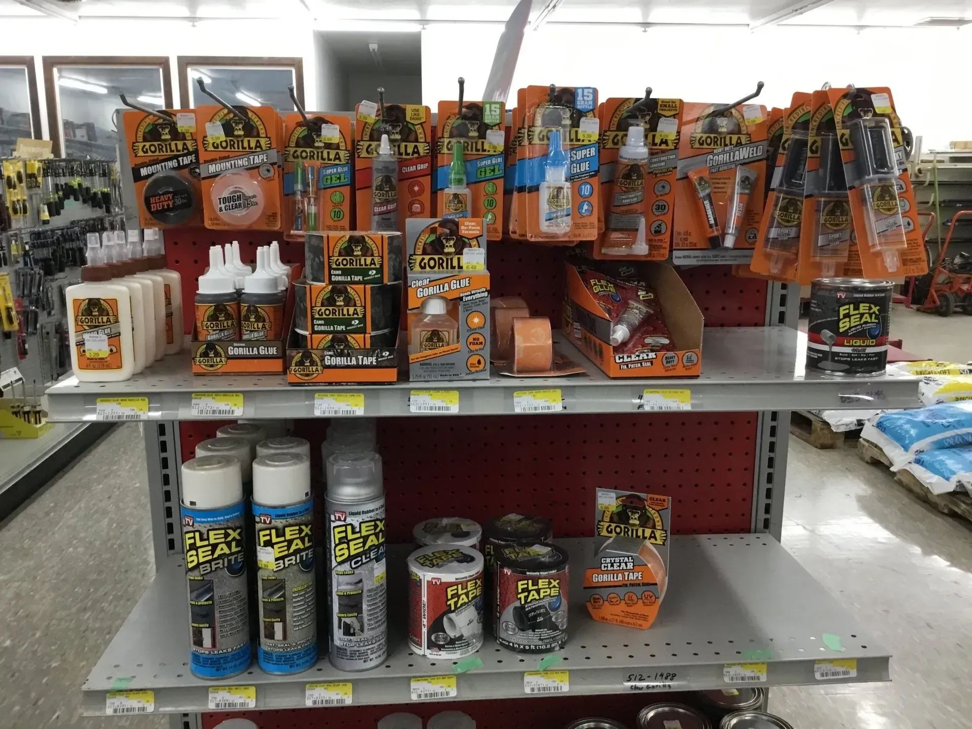 Store shelf filled with assorted colorful fireworks and pyrotechnic items in orange and black packaging