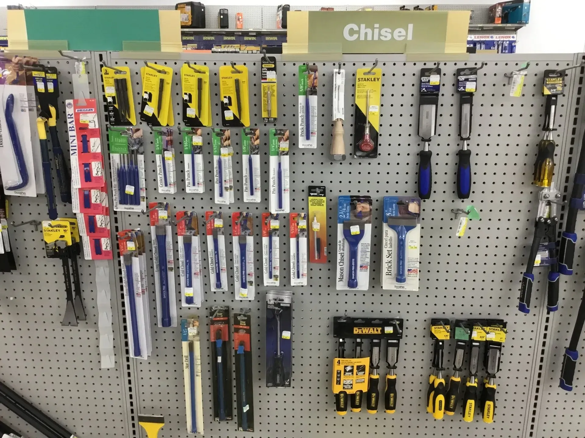 Pegboard display of assorted chisels and hand tools in a hardware store.