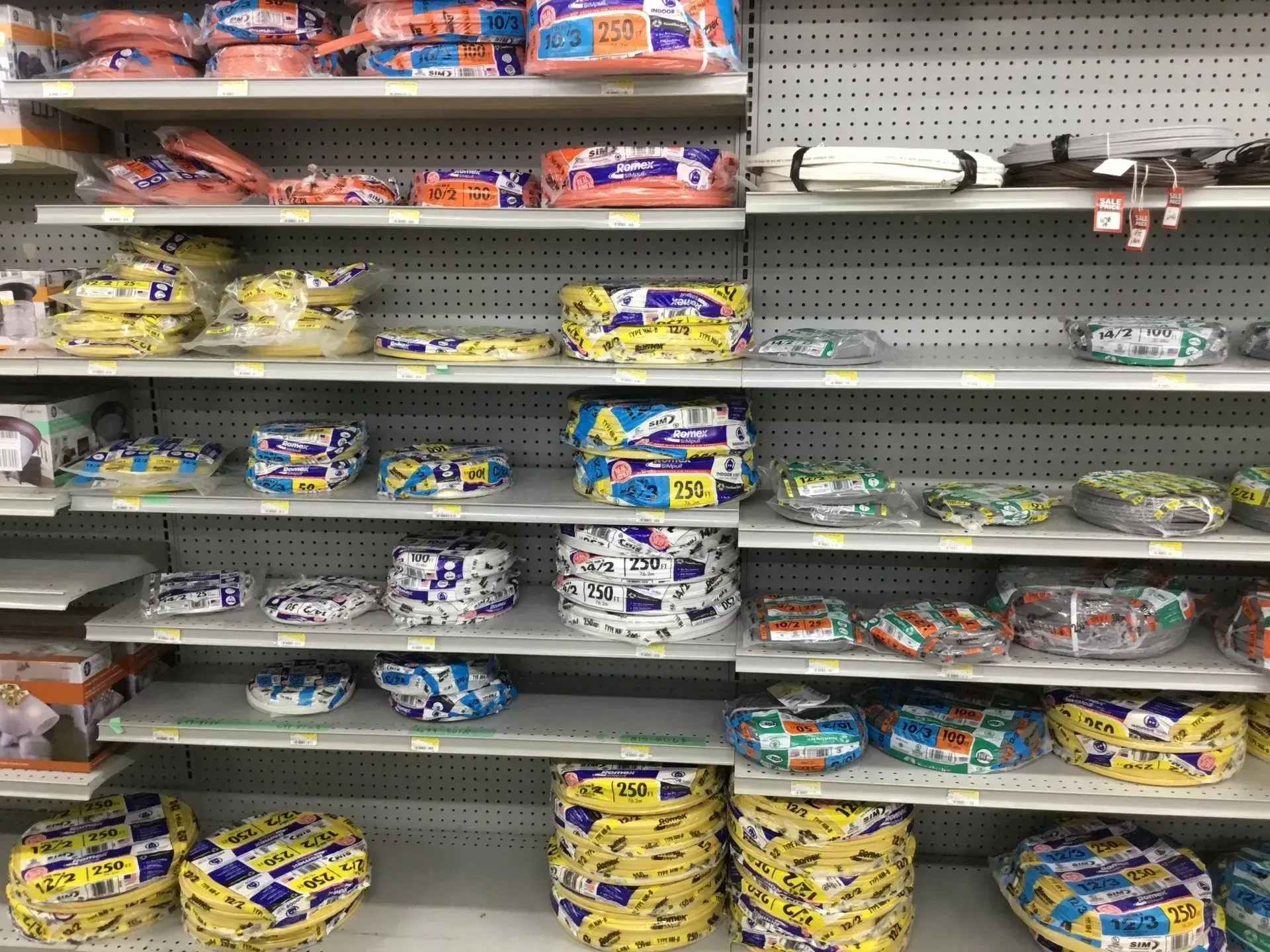Shelves in a grocery aisle mostly empty, with a few packs of snacks and baking ingredients remaining