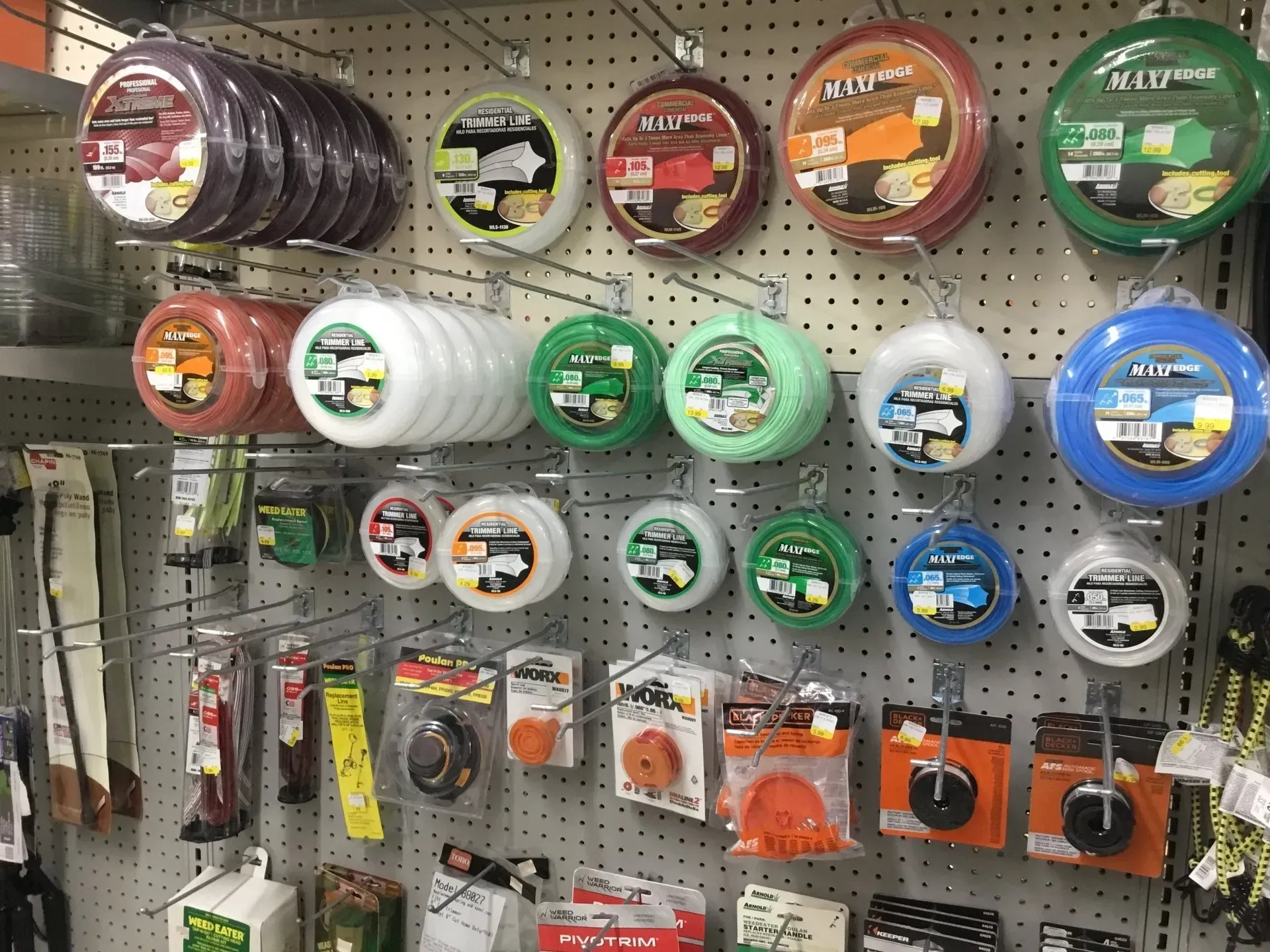 Pegboard display of fishing line spools and lures in assorted colors at a tackle shop