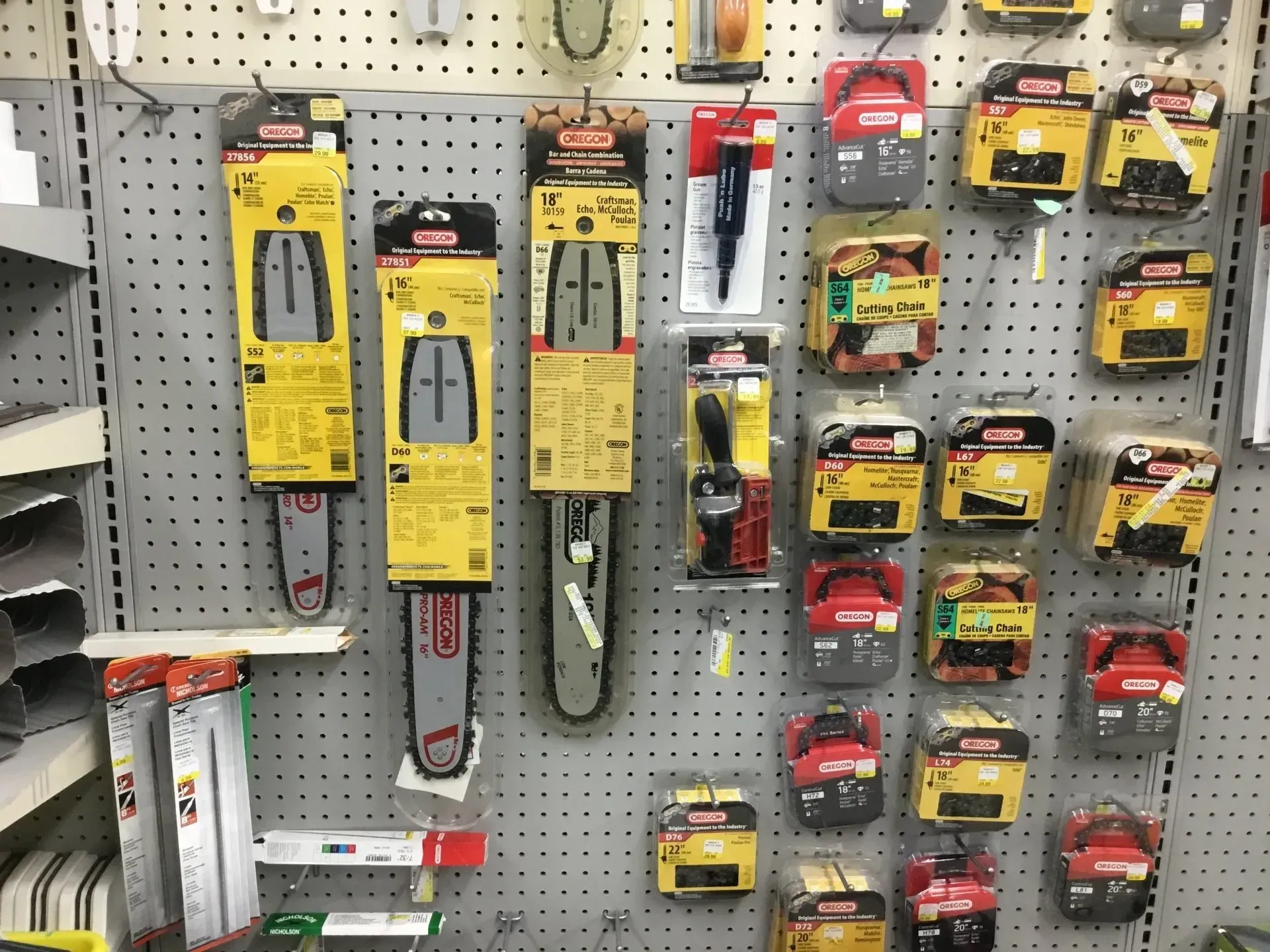 Pegboard display of assorted boxed hand tools and hardware accessories in a store aisle