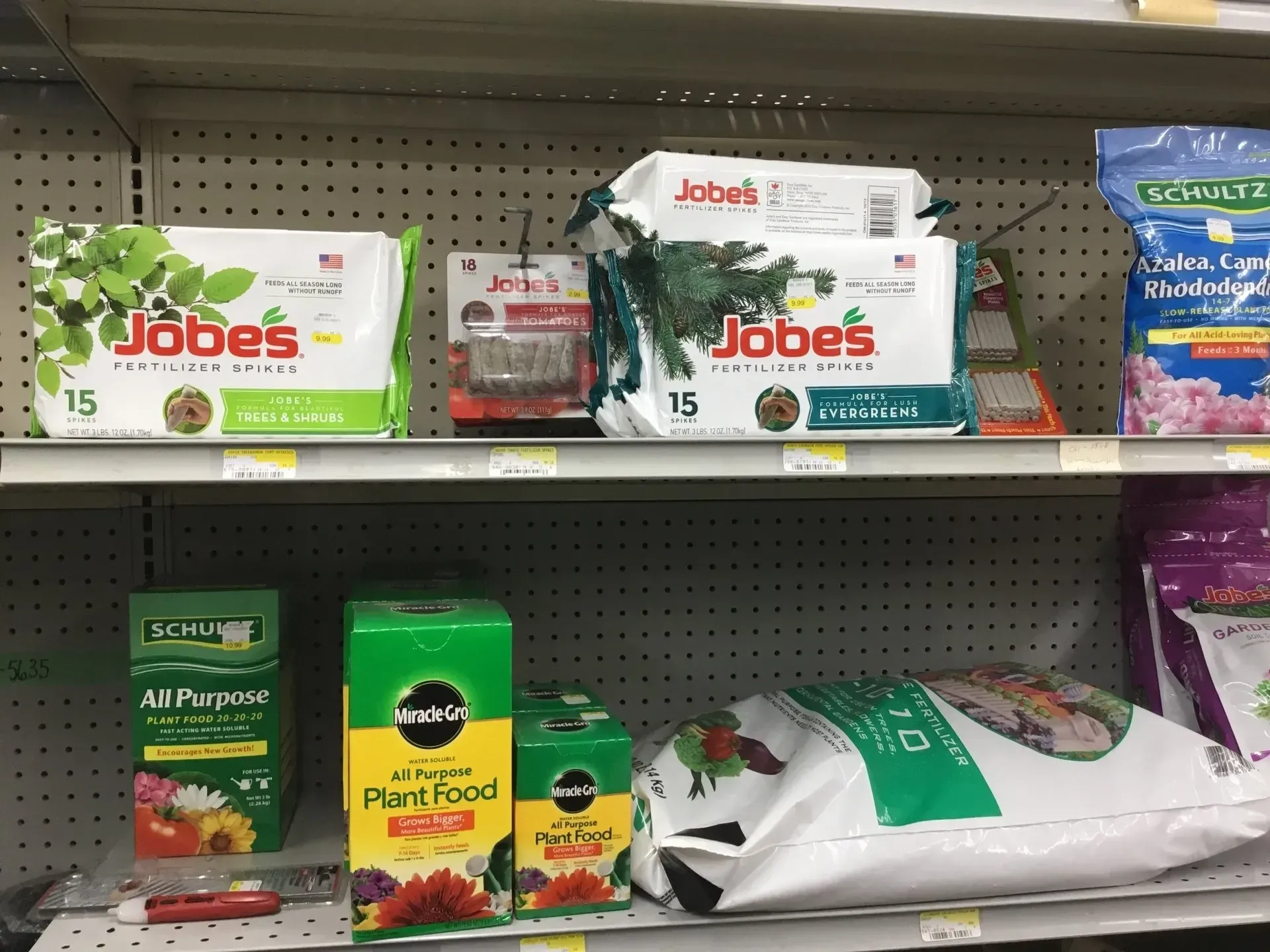 Store shelf with Jobe’s gardening products in white, green, and yellow packaging