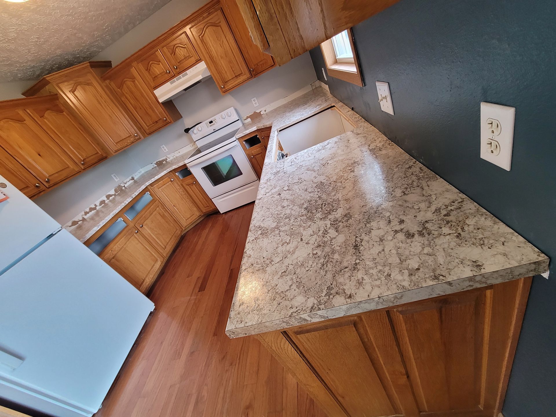Kitchen with wooden cabinets, white appliances, and a granite countertop.