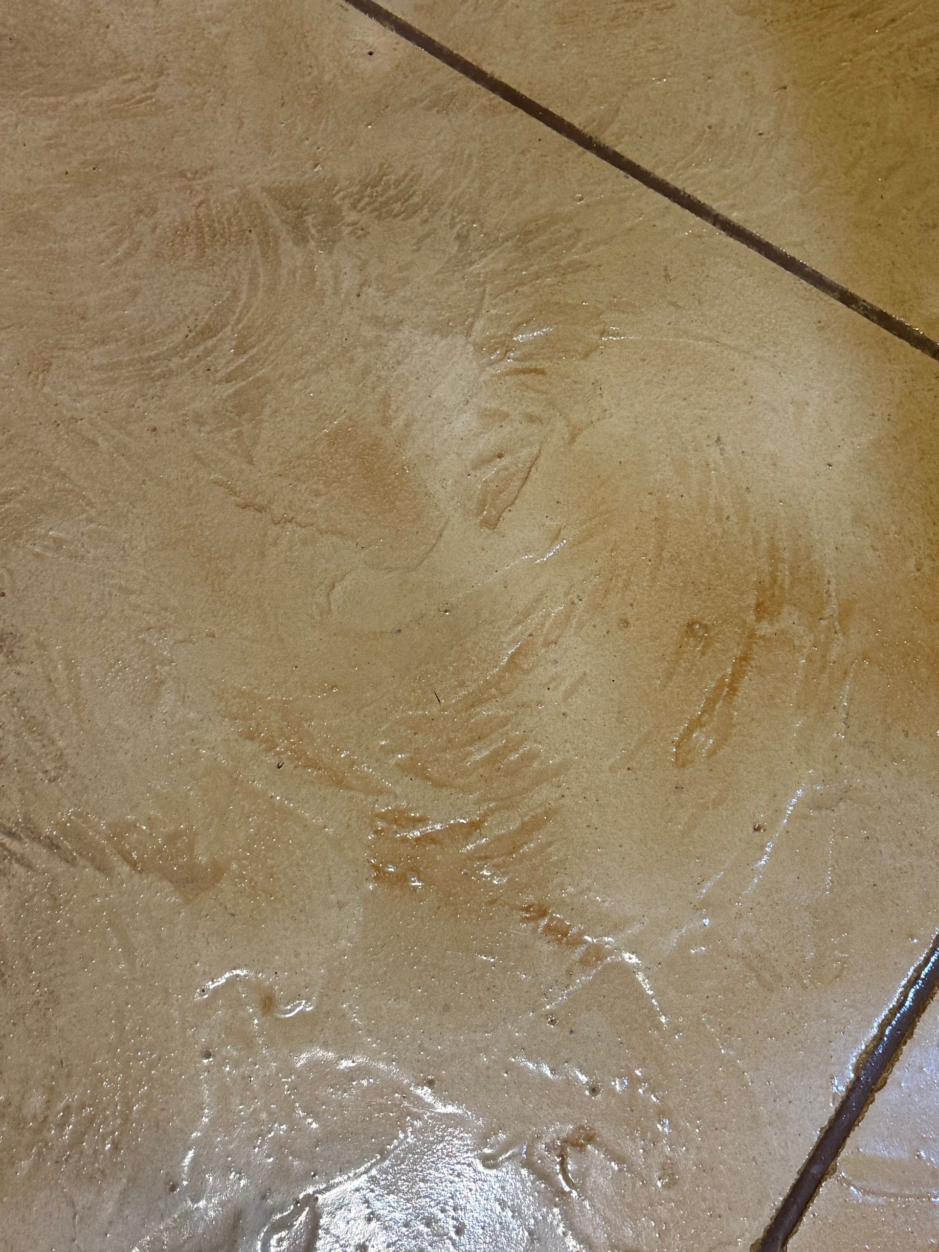 Tan and brown patterned concrete floor with dark diagonal lines.