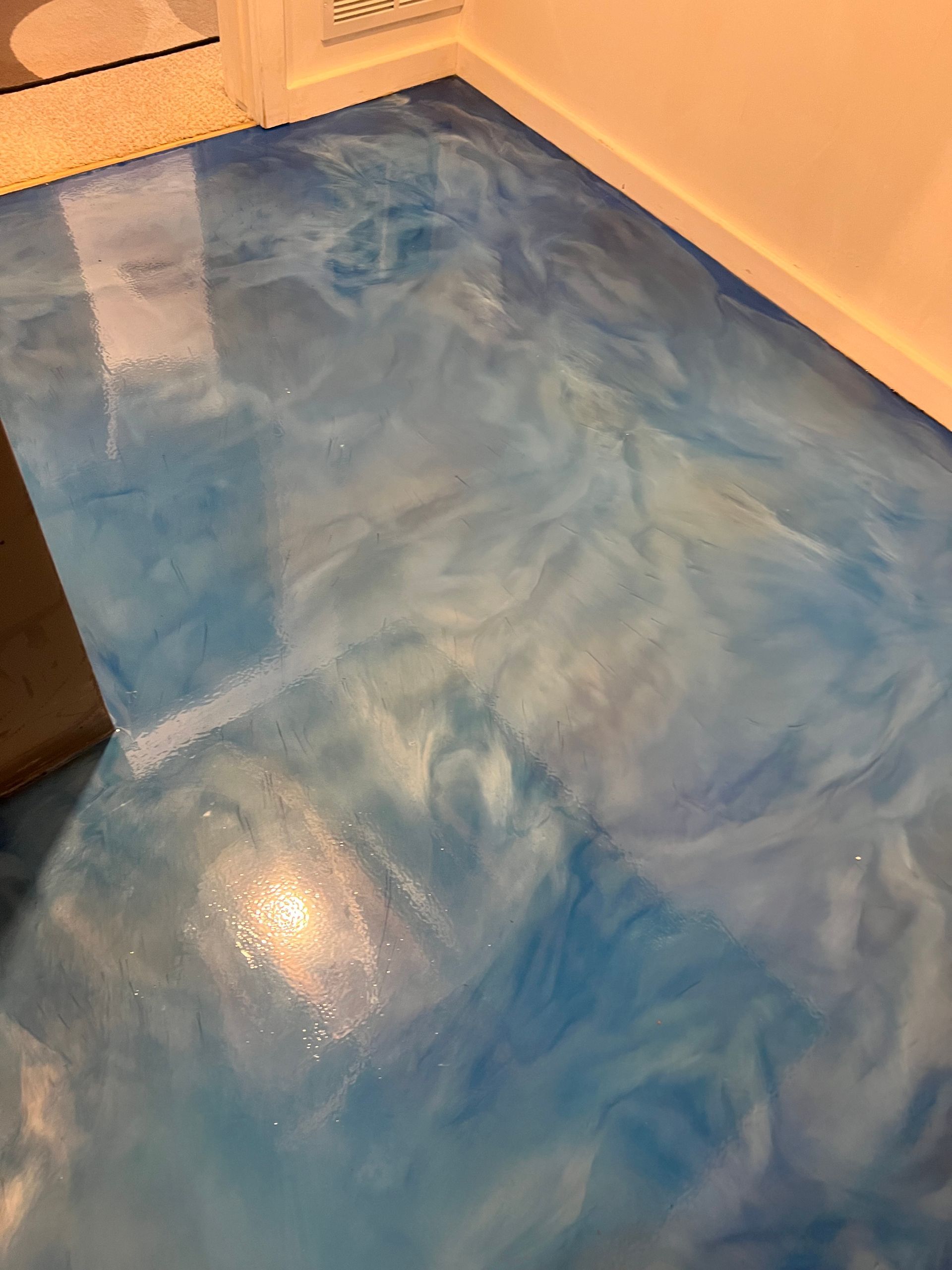 Blue and white marbled epoxy floor with glossy finish.