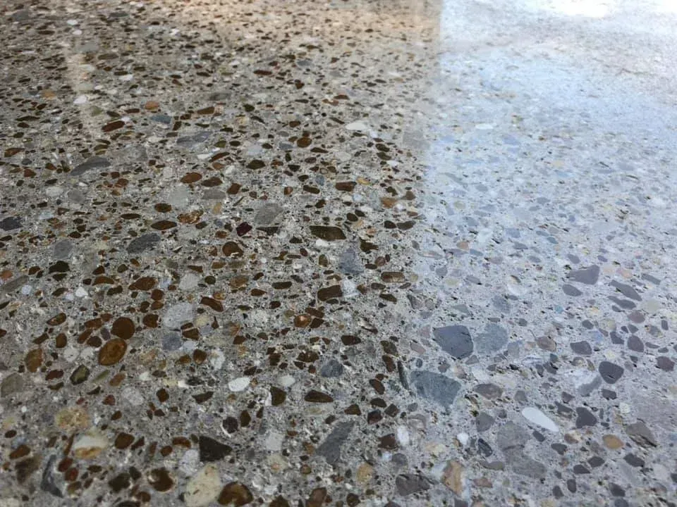 Polished concrete floor with exposed aggregate, light and dark tones.