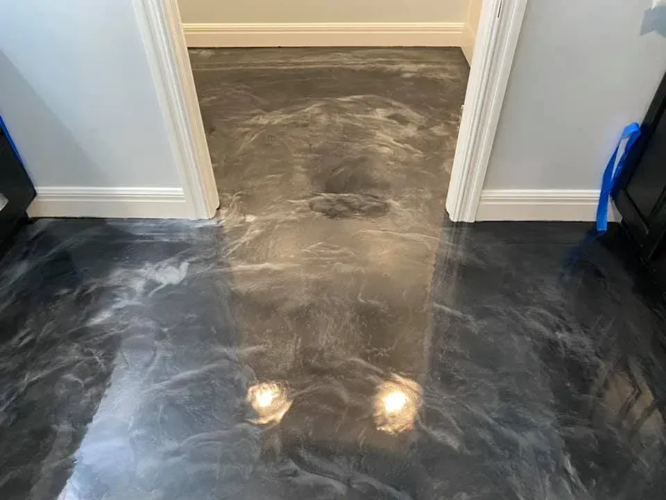 Metallic epoxy flooring in a hallway, shades of gray and silver, reflective surface.