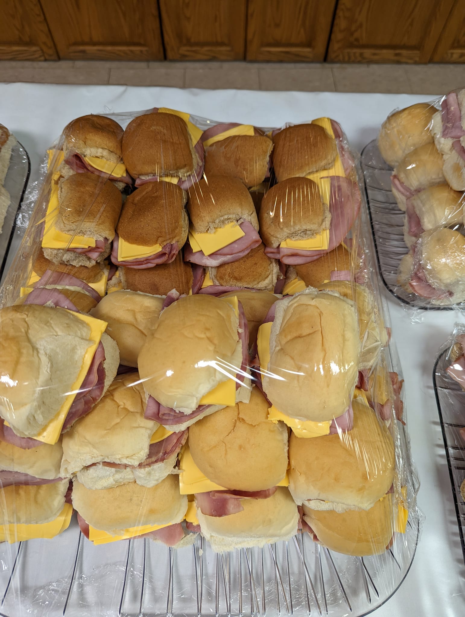 A tray of ham and cheese sliders on a table.