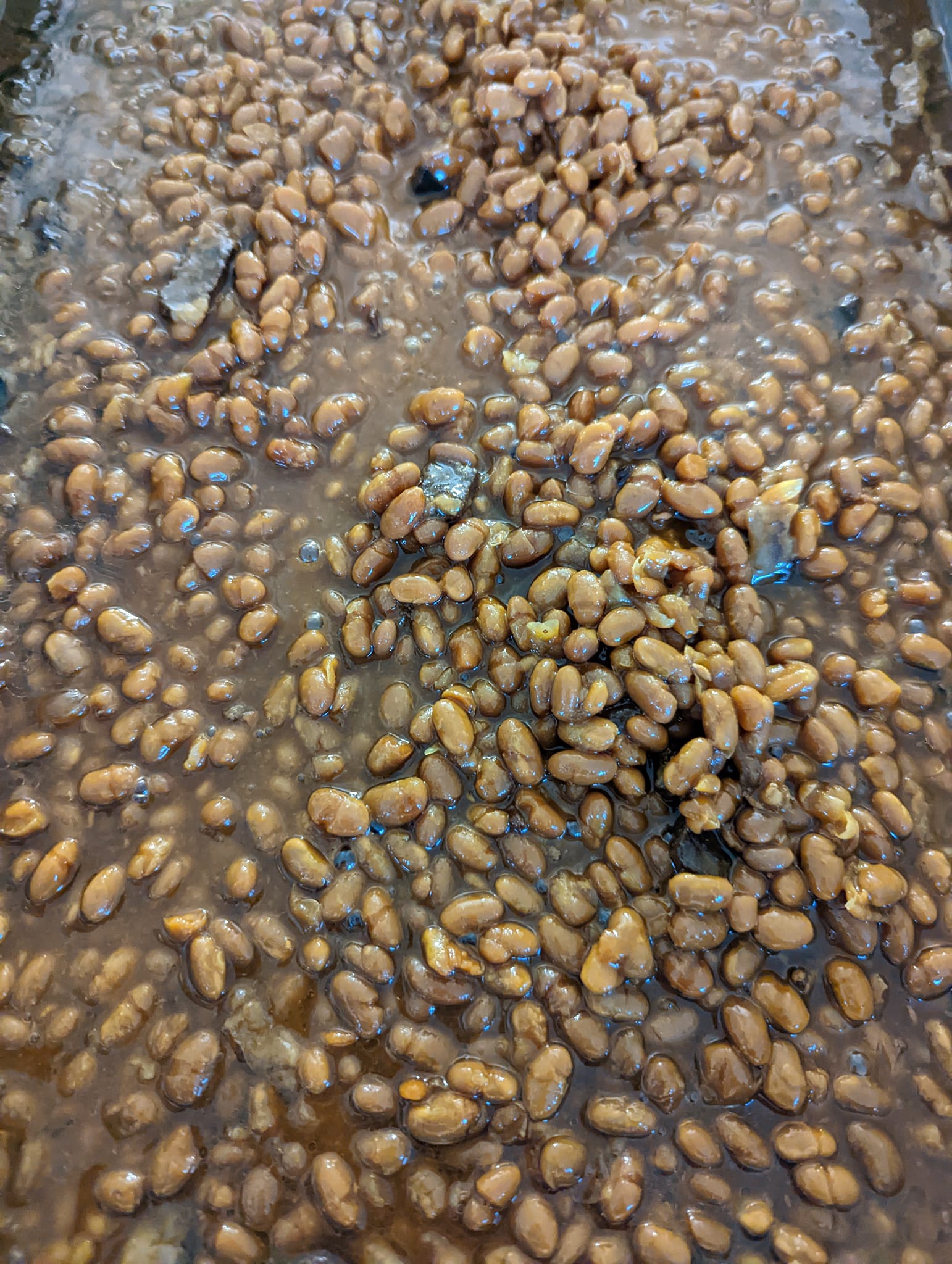 A close up of a pile of baked beans in a pan.