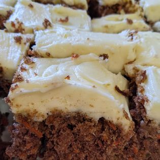 A close up of a piece of chocolate cake with white frosting.