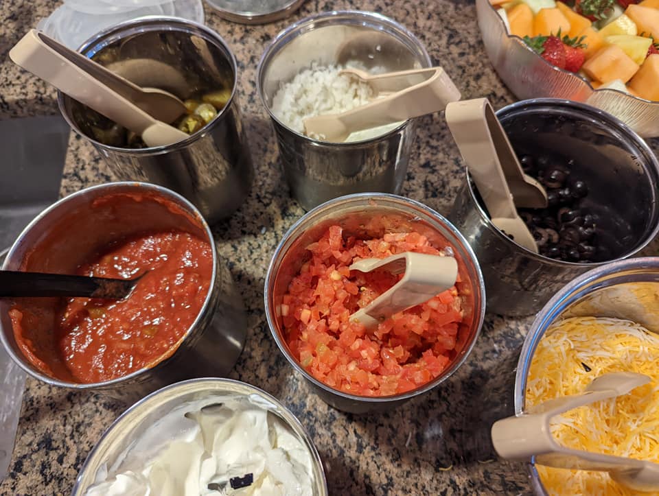 A buffet table with a variety of sauces and toppings