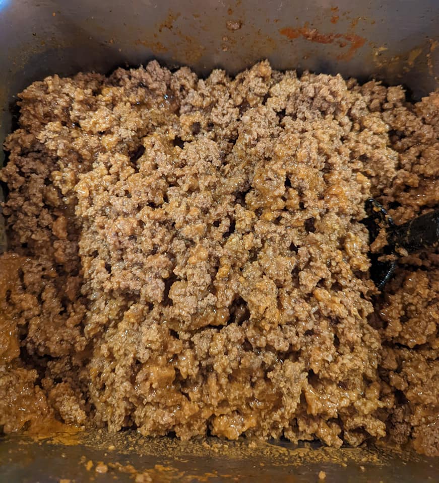 A close up of a pile of ground beef in a pan.