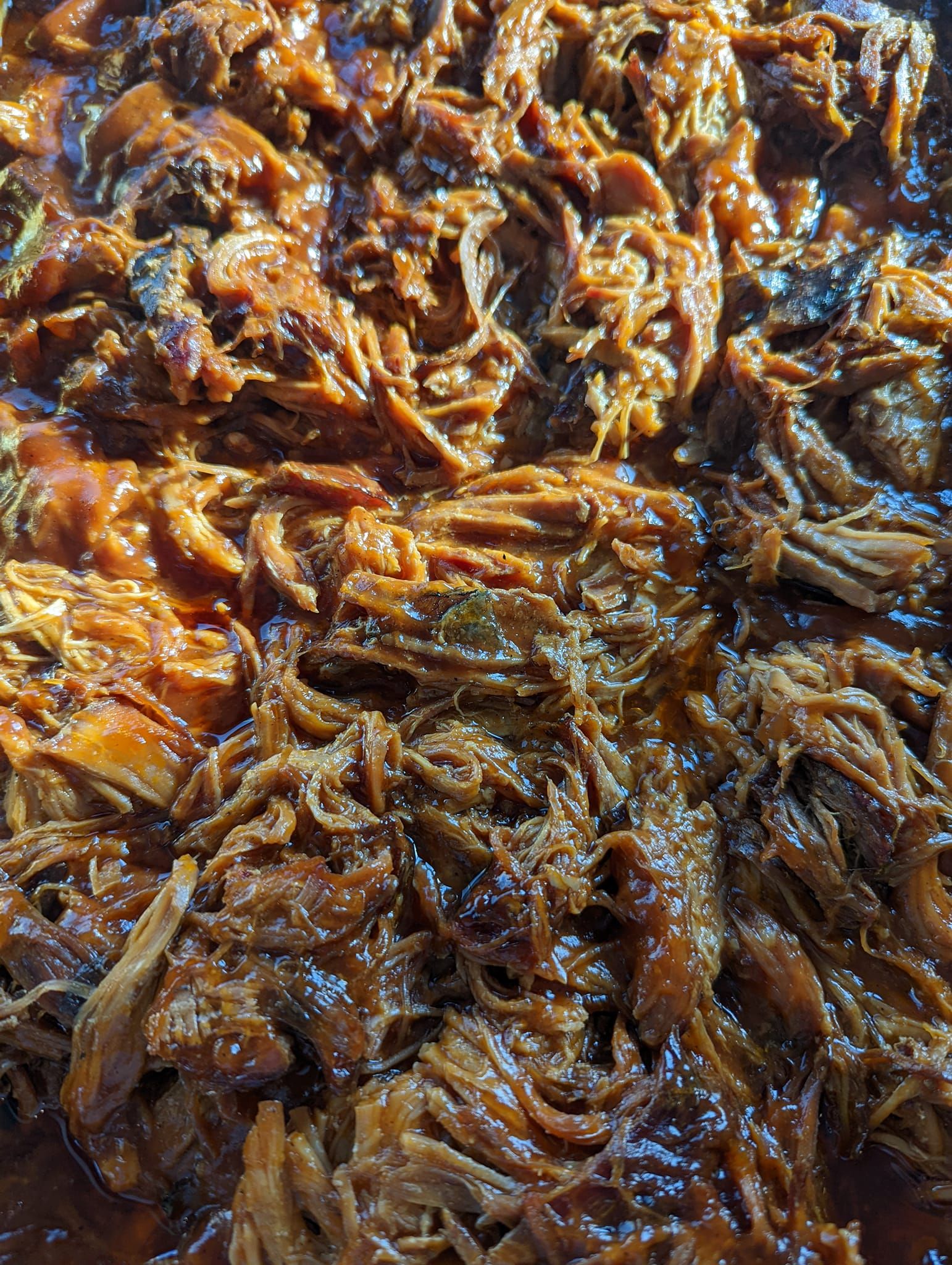 A close up of a pan of pulled pork in sauce.