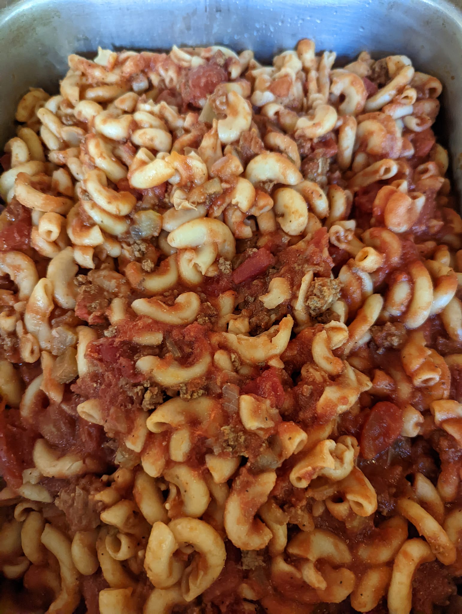A casserole dish filled with macaroni and cheese and tomato sauce.
