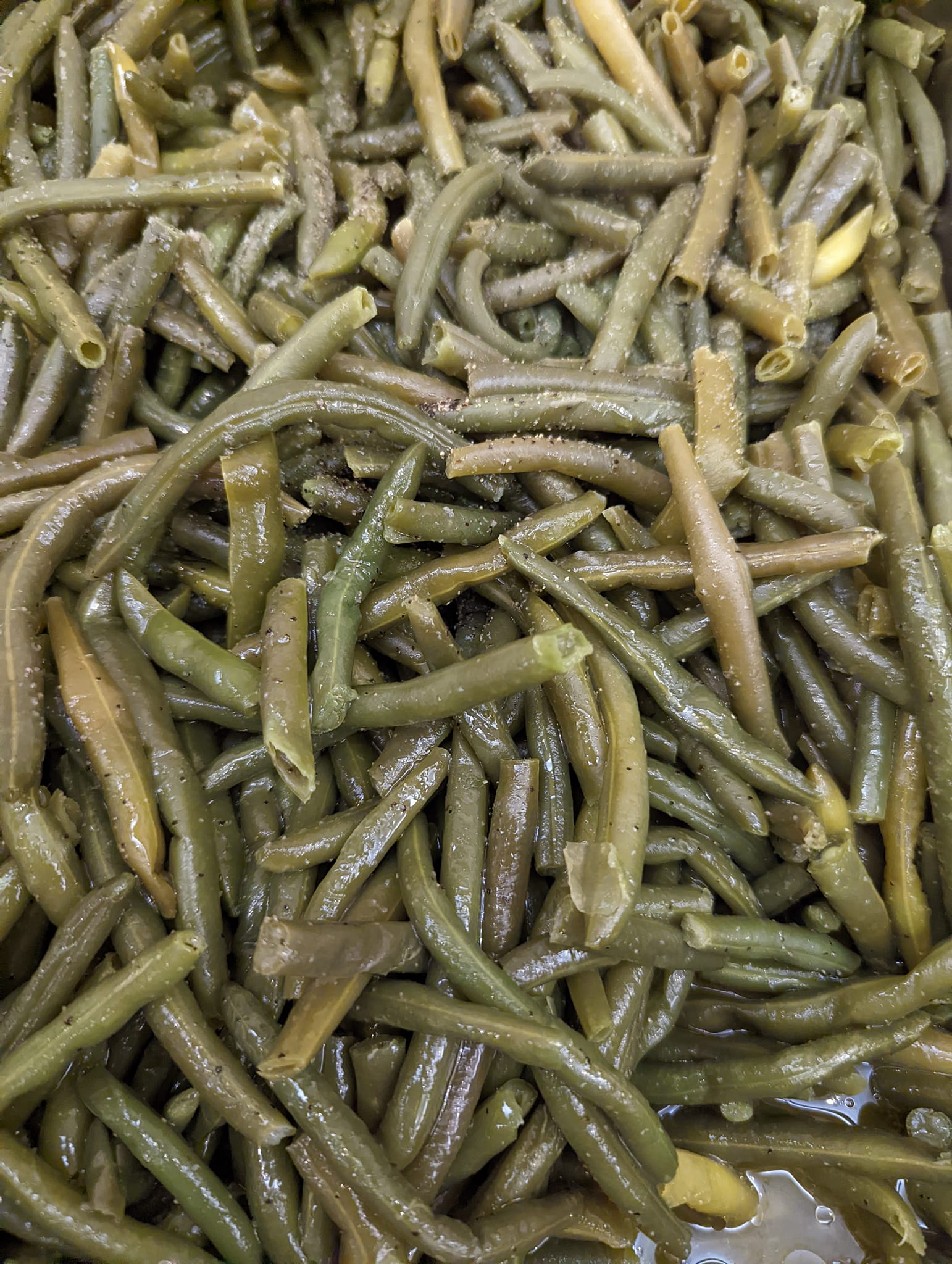 A close up of a pile of green beans in a bowl.