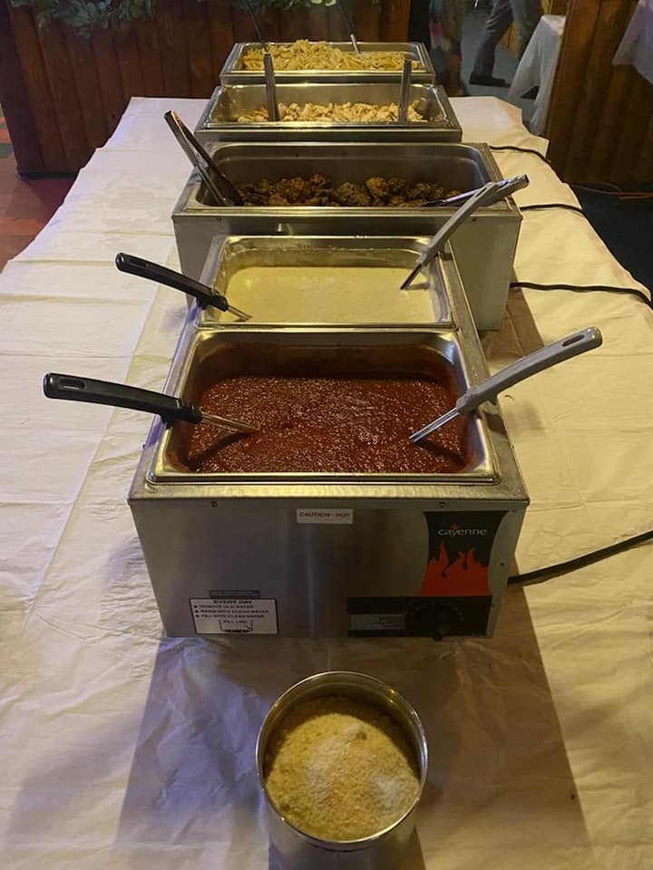 A buffet line with a variety of food and sauces on a table.