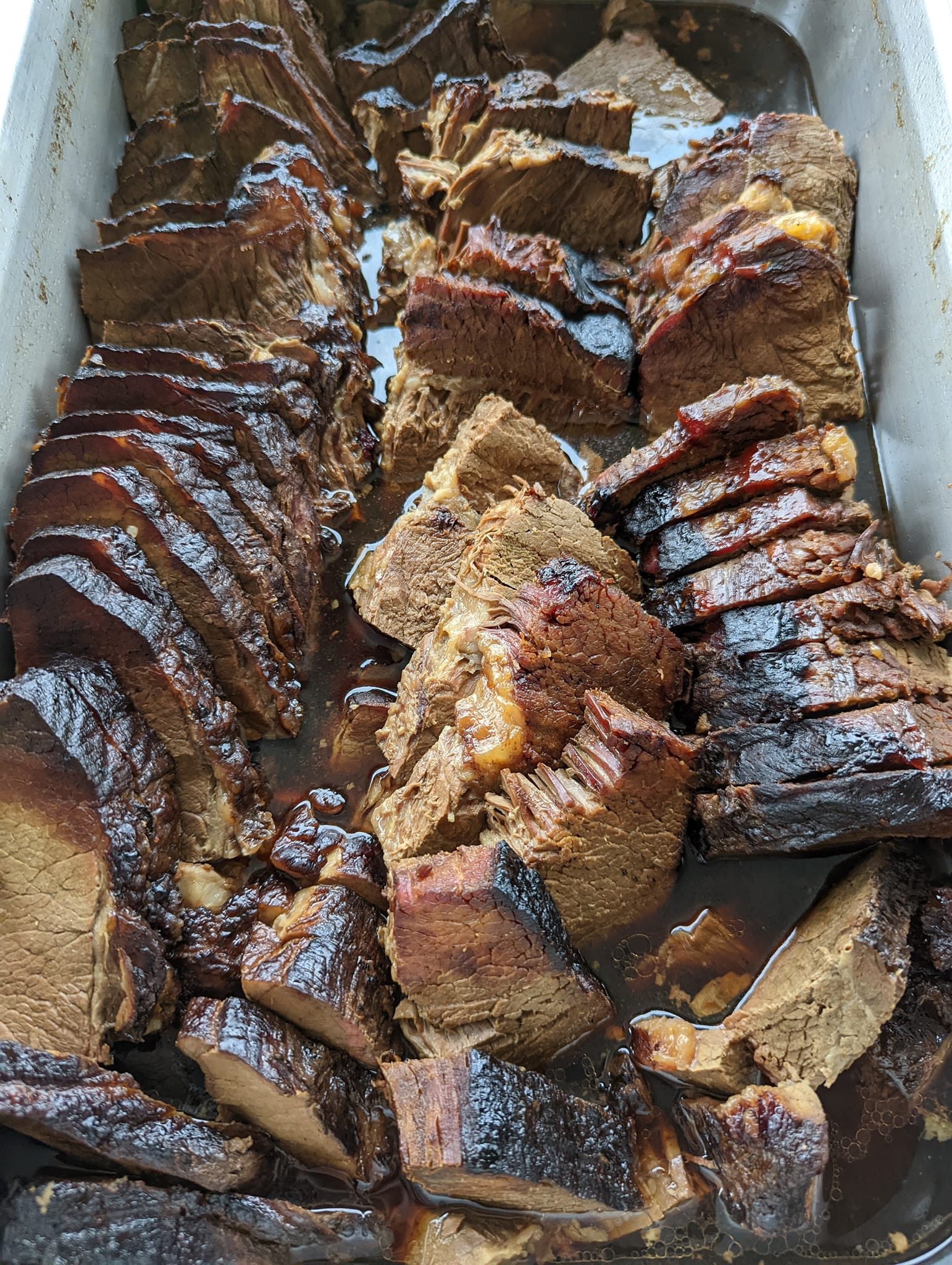 A casserole dish filled with sliced meat and sauce.