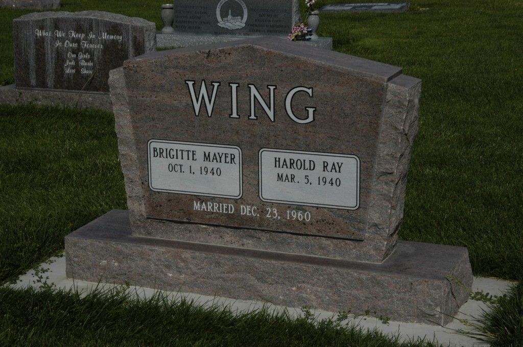 A gray granite headstone with the last name WING, listing dates of birth and death for a couple.