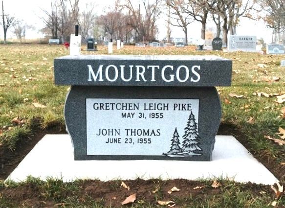 Gray granite tombstone in a cemetery with the last name Mourtgos and names of John Thomas and Gretchen Leigh Pike.