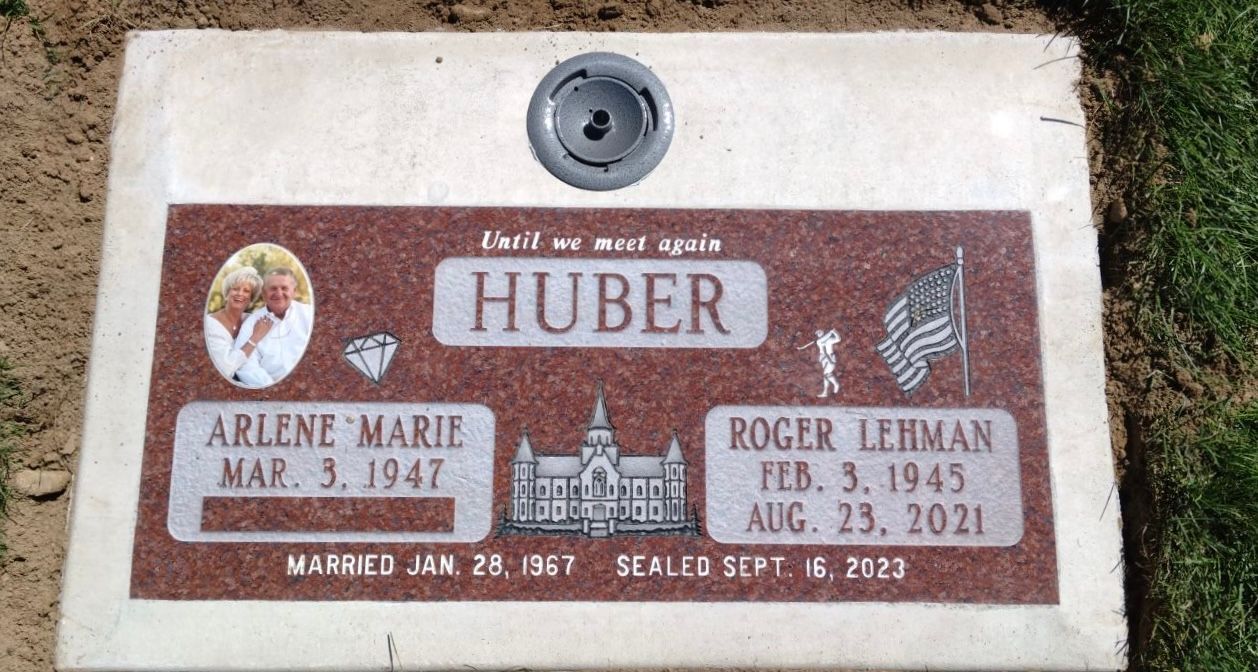 Headstone for Huber couple: Arlene Marie (1947-) & Roger Lehman (1943-2021). Red and white granite with photos and dates.