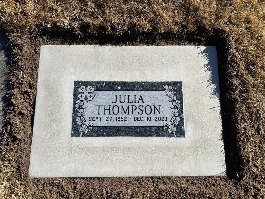 Grave marker of Julia Thompson, with dates Sept. 27, 1952 - Dec. 03, 2023, set in a freshly dug plot.