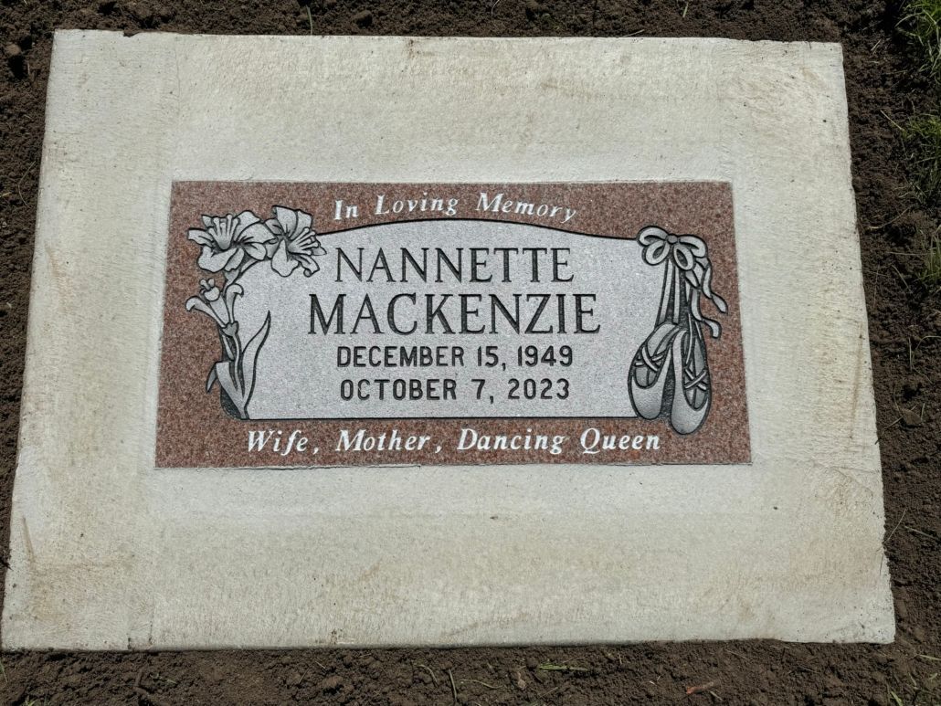 Headstone for Nannette MacKenzie: red granite, flowers, ballet shoe, birth/death dates.