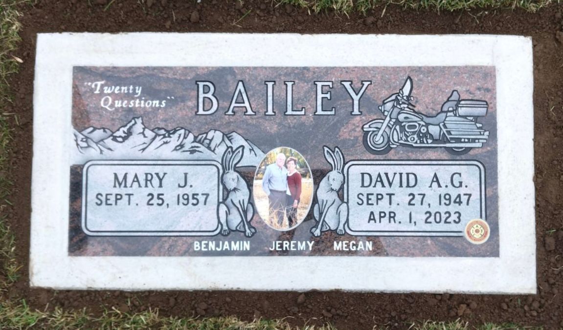 Headstone for Mary J. Bailey and David A.G. Bailey. Includes dates, names, a photo, a motorcycle, and bunny art.