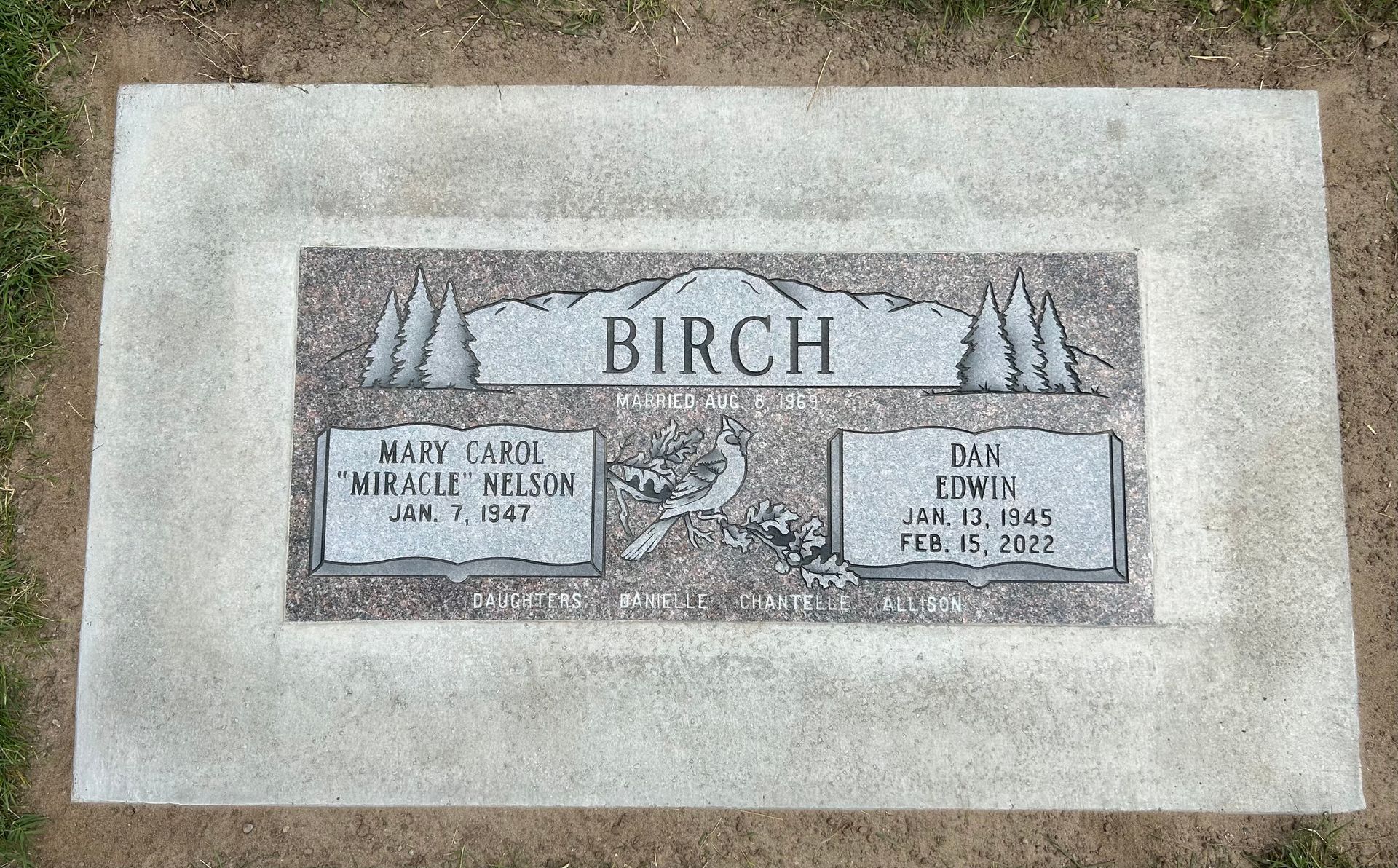 Gravestone for the Birch family. Gray stone with names and dates set in a concrete border.
