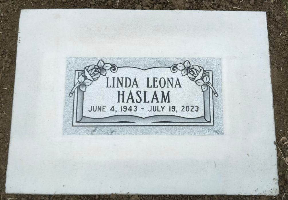 Headstone for Linda Leona Haslam: dates June 4, 1943 - July 19, 2023, with rose design.