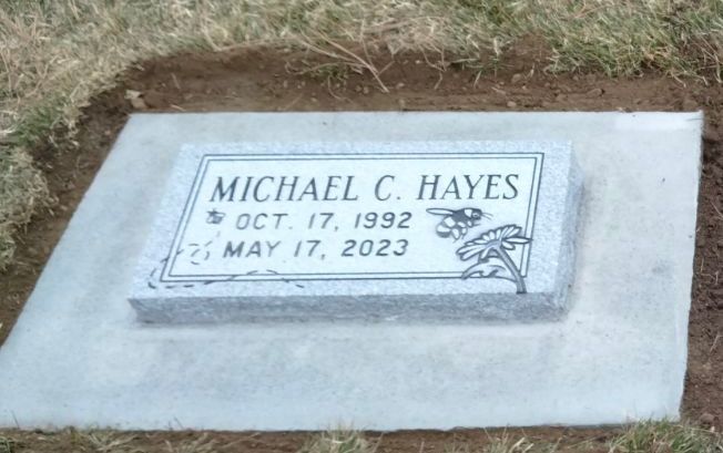 Headstone for Michael C. Hayes, born Oct. 17, 1992, died May 17, 2023, with simple floral design, set in concrete.
