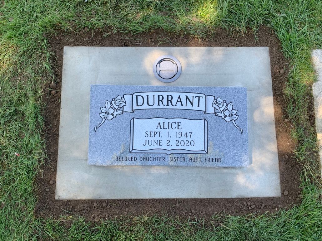 Gravestone of Alice Durrant: gray stone with name, birth/death dates, floral design, set in rectangular concrete base.