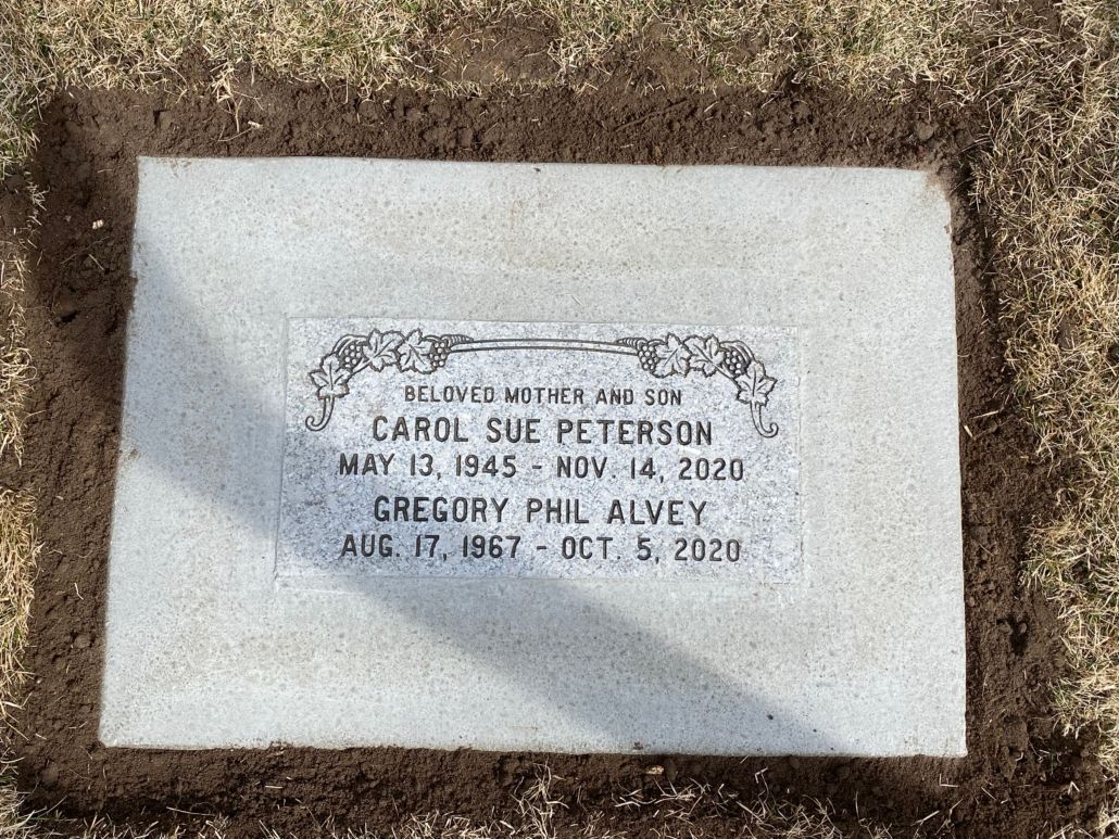 Headstone: Carol Sue Peterson (1945-2020) and Gregory Phil Alvey (1967-2020) in a grassy plot.