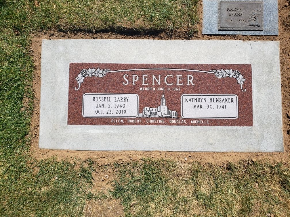 Headstone of the Spencer family. Red granite with names and dates on a light stone base.
