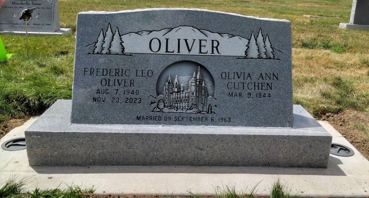 Gravestone for Frederic Leo Oliver and Olivia Ann Cluchen, featuring a mountain and tree design.